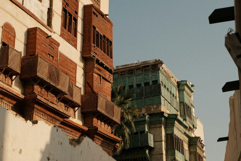 A historic coral-stone building with a palm tree in Jeddah