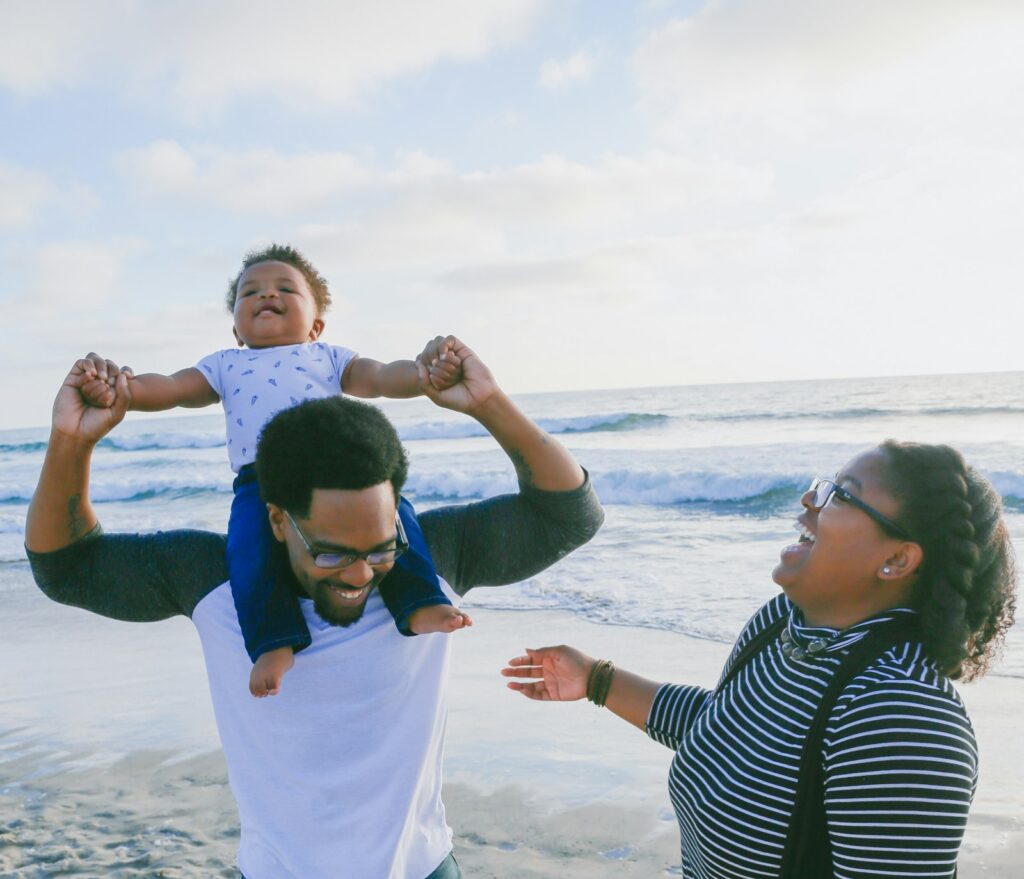 A family walking along a white sand beach at golden hour