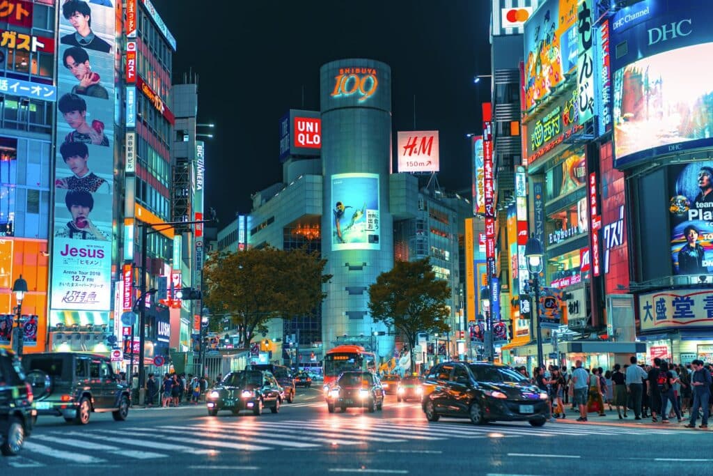 A neon-lit intersection in Shibuya, Tokyo, at night