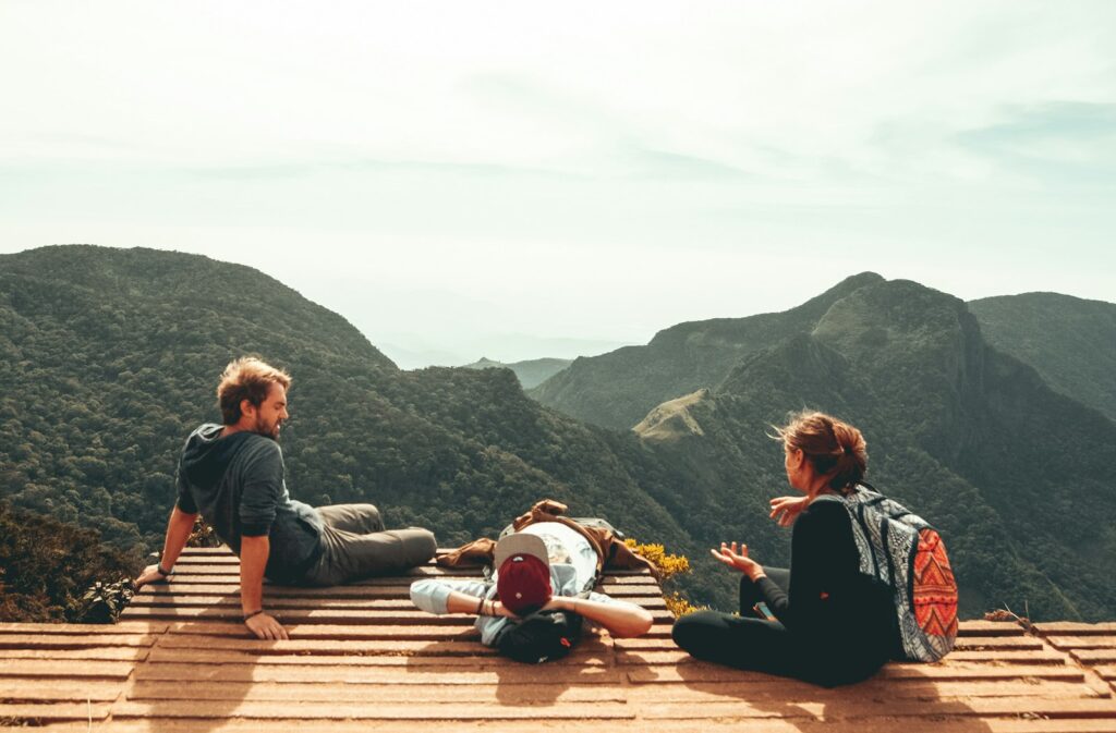 Three travellers looking out over a mountain range